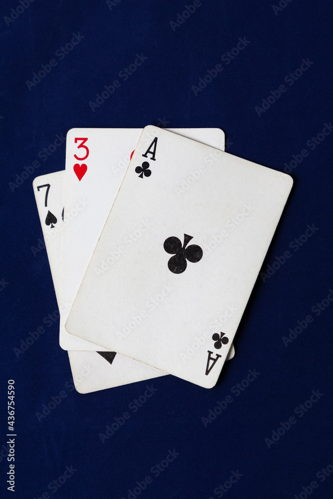 Three playing cards lie on a blue cloth
