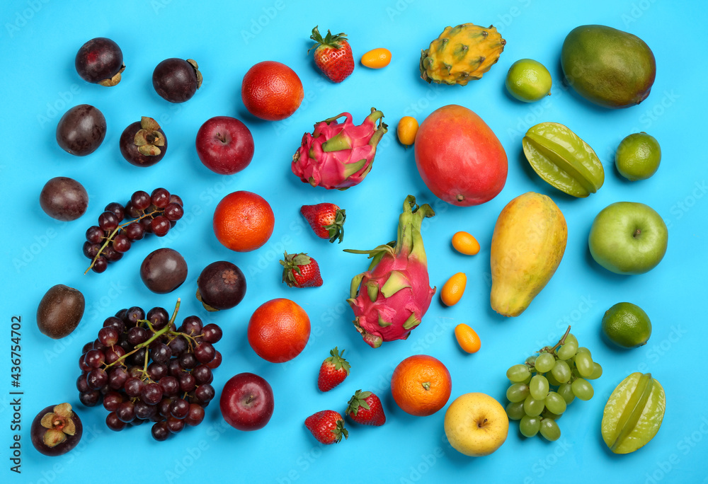 Assortment of fresh exotic fruits on light blue background, flat lay