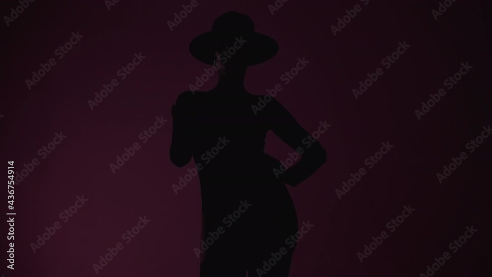 Silhouette of woman in hat, bodysuit and stockings walking forward to camera under flashing violet light, broken bulb effect. Lady on colorful background. Silhouette of woman in hat, bodysuit and stockings walking forward to camera under flashing violet light, broken bulb effect. Lady on colorful background.