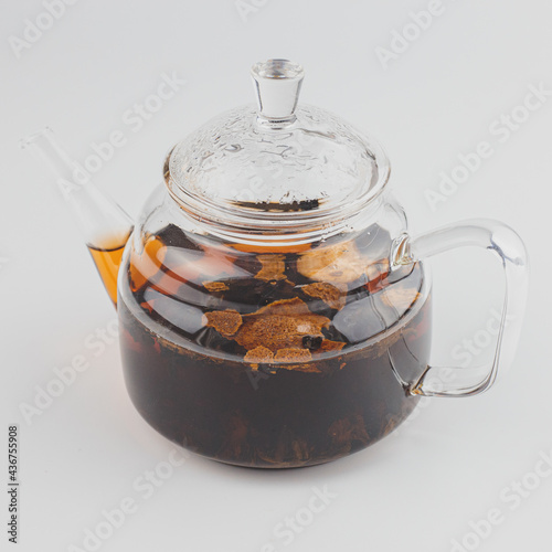 glass teapot filled with pu-erh tea in tangerine