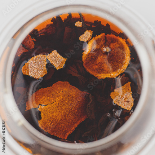 brewed pu-erh in tangerine in a glass teapot top view