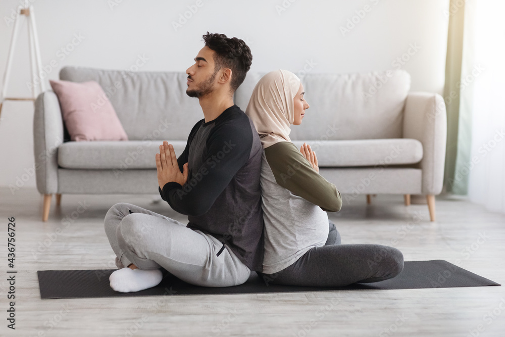 Pregnancy Yoga. Expectant Middle Eastern Couple Meditating Together At Home Pregnancy Yoga. Expectant Middle Eastern Couple Meditating Together At Home