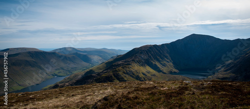 a view looing down in the crater of Cadair Idris with a mountain view behind it 