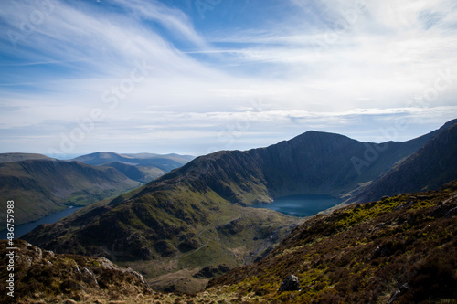 a view looing down in the crater of Cadair Idris with a mountain view behind it 