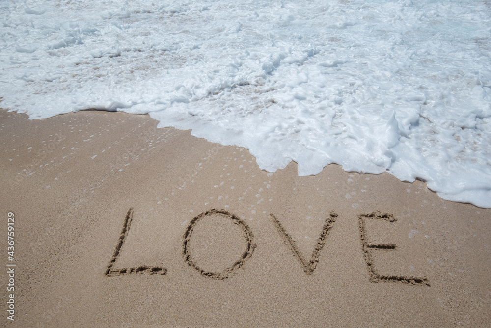 Fototapeta premium Word love written on the golden sand