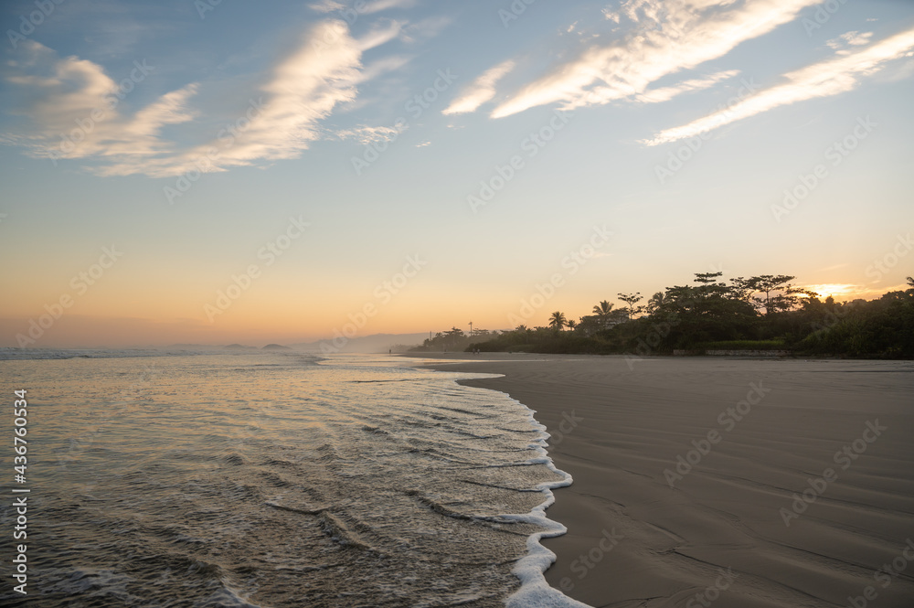Lindo por do Sol na praia de Guaratuba, litoral Brasileiro. Mar avançando sobre a areia da praia vazia