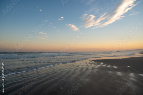 Lindo por do Sol na praia de Guaratuba  litoral Brasileiro. Mar avan  ando sobre a areia da praia vazia