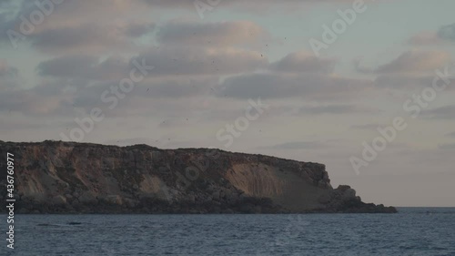 Rocky shore of Agios Georgios Cyprus. View of the island Yeronisos. Sunset at Agios Georgios Pegeias harbor in Paphos, Cyprus. The Akamas peninsula and the island of Geronisos photo