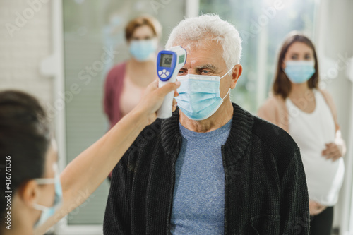 Senior Man Having Her Temperature Checked Before Covid-19 Vaccine