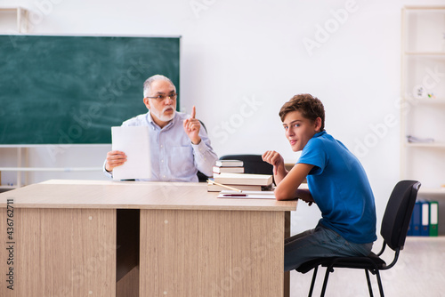 Old male teacher and schoolboy in the classroom