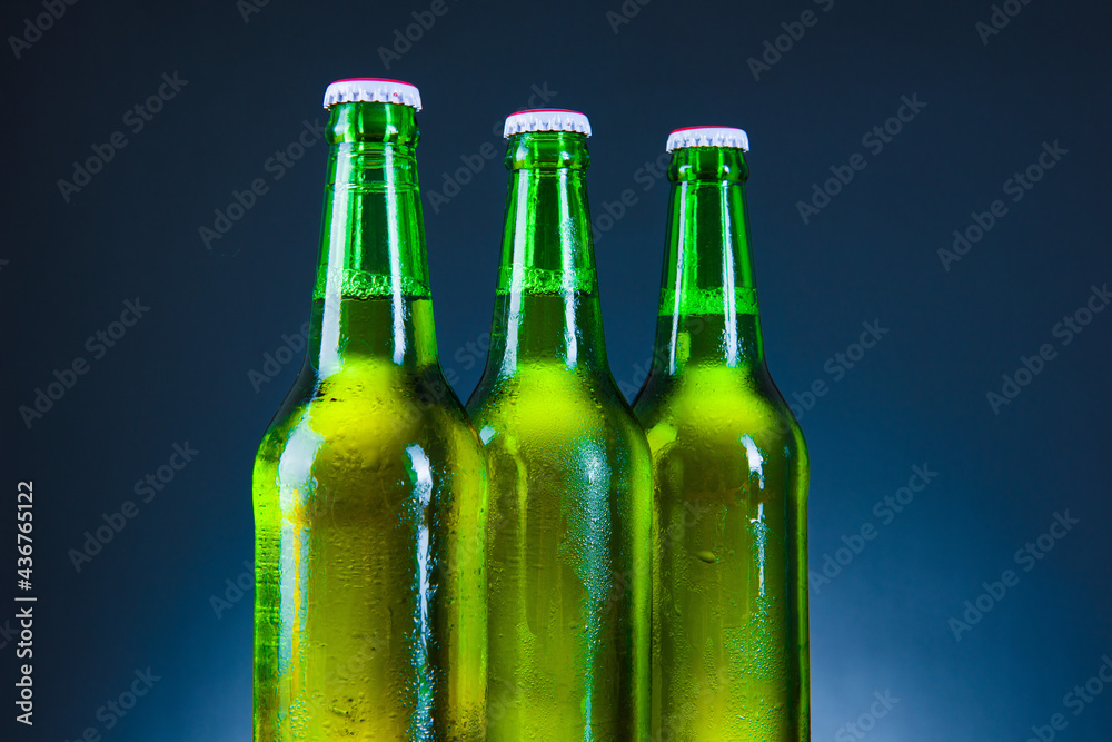 green beer bottle with drops on blue background