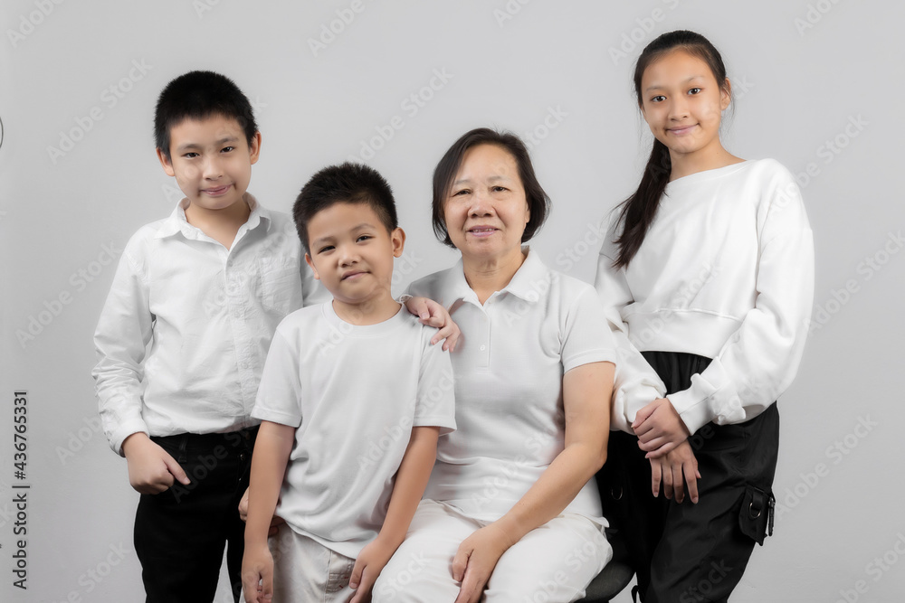Portrait of Grandmother and grandchild hugging, looking at camera and smiling, on gray background Portrait of Grandmother and grandchild hugging, looking at camera and smiling, on gray background