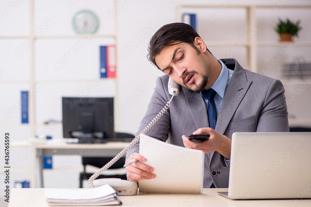 Fototapeta premium Young male employee working in the office