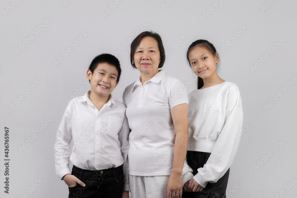 Portrait of Grandmother and grandchild hugging, looking at camera and smiling, on gray background Portrait of Grandmother and grandchild hugging, looking at camera and smiling, on gray background