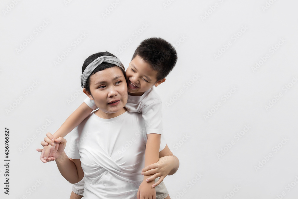 Young adult female cancer patient spending time with little son on gray background. Cancer and family support concept. Young adult female cancer patient spending time with little son on gray background. Cancer and family support concept.
