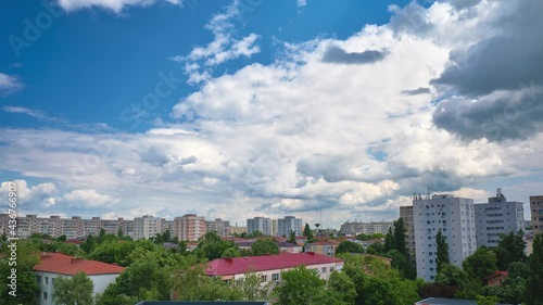 Cumulus mediocris clouds time lapse with shadows on city buildings. Tilt down, timelapse, urban. photo