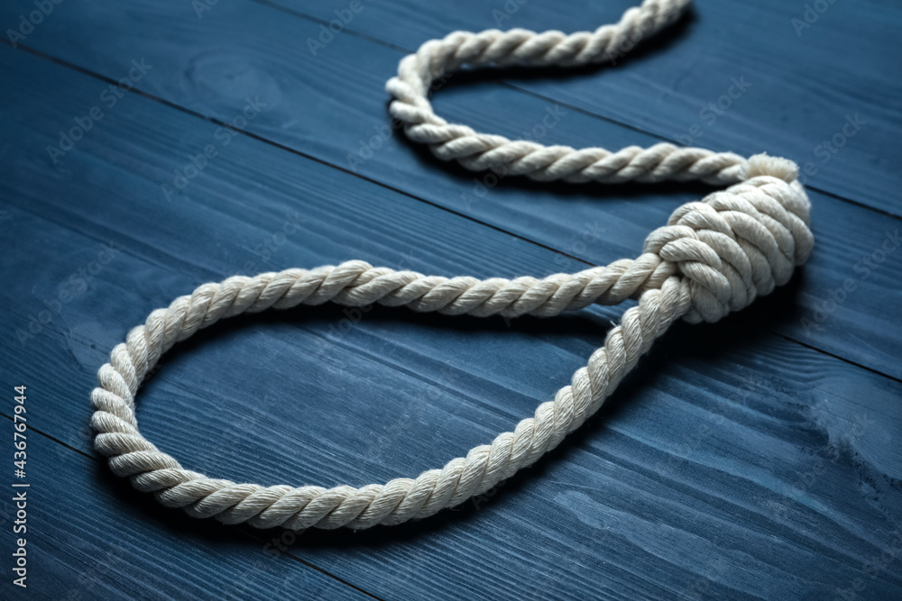 Obraz premium Rope noose with knot on blue wooden table, closeup