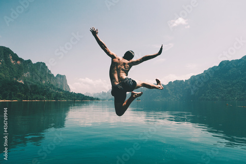 Tablou canvas Man jumping with joy by a lake