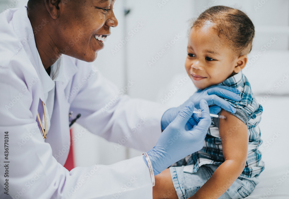 Toddler getting a vaccination by a pediatrician Toddler getting a vaccination by a pediatrician