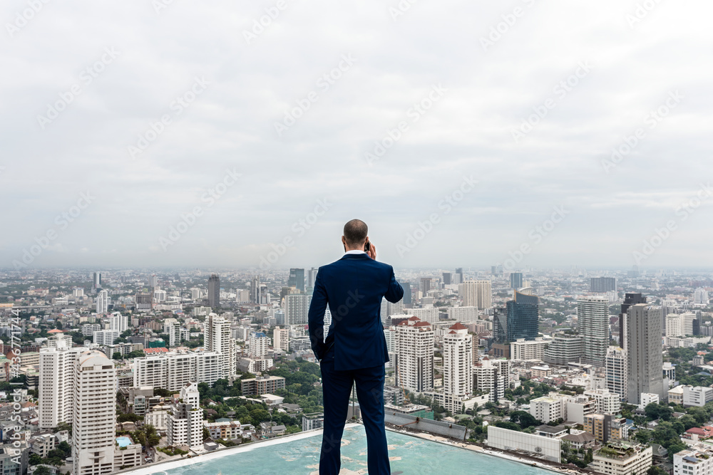 Business man talking on a phone with a cityscape background Business man talking on a phone with a cityscape background