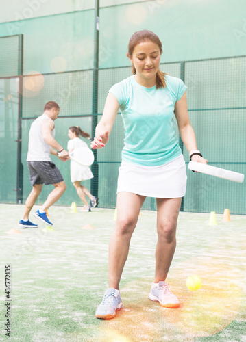 Emotional young adult woman training padel at warm sunny day © JackF