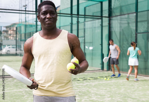 African american man and latino woman playing paddle tennis outdoor