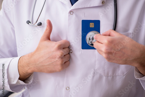 Male doctor holding credit card