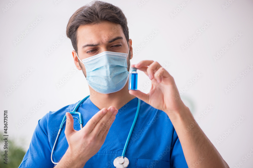 Young male doctor in vaccination concept during pandemic Young male doctor in vaccination concept during pandemic