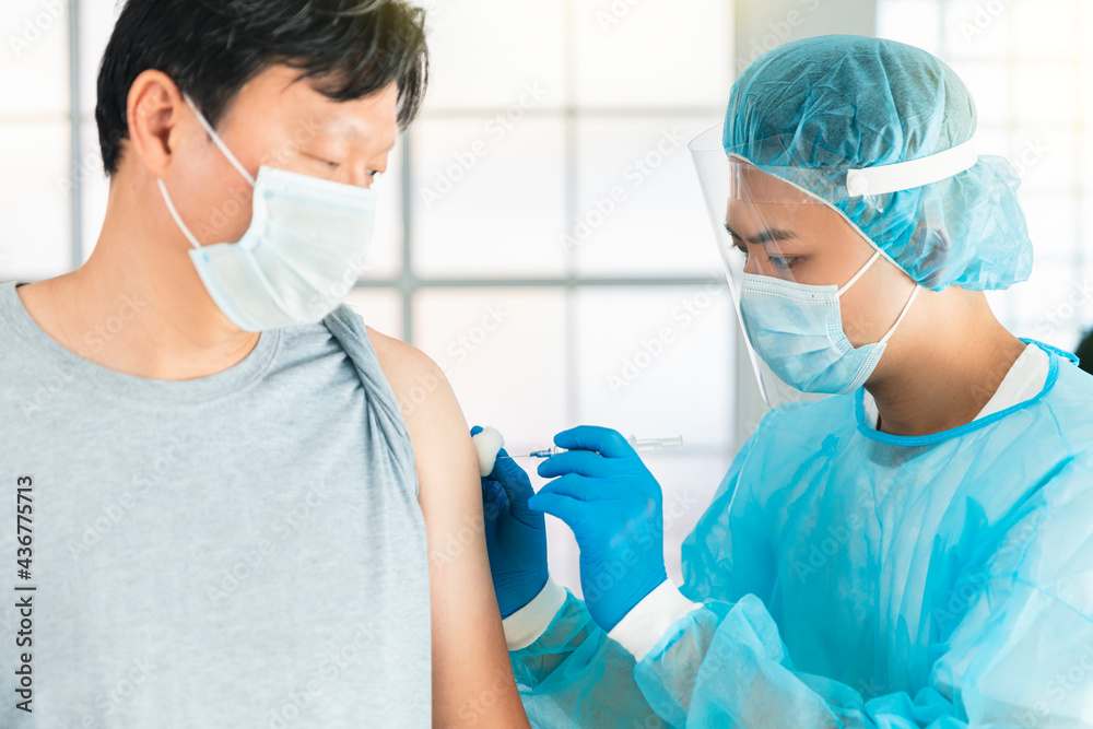 doctor wearing face protective medical mask for protection from virus disease with syringe doing injection of vaccine to male patient doctor wearing face protective medical mask for protection from virus disease with syringe doing injection of vaccine to male patient