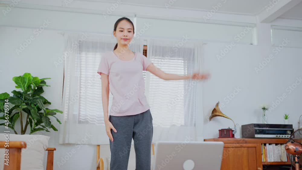 Sport girl watch aerobic workout video on laptop and exercise at home Sport girl watch aerobic workout video on laptop and exercise at home