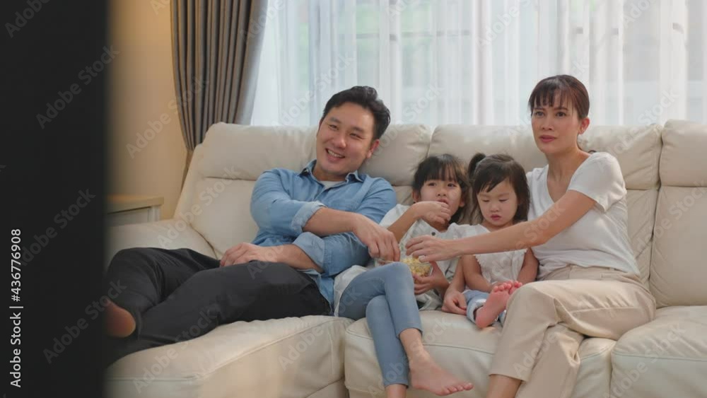 Happy Family at home, Parent and daughter watch movie on TV together Happy Family at home, Parent and daughter watch movie on TV together