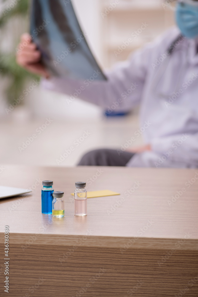 Old male doctor radiologist working in the clinic during pandemi