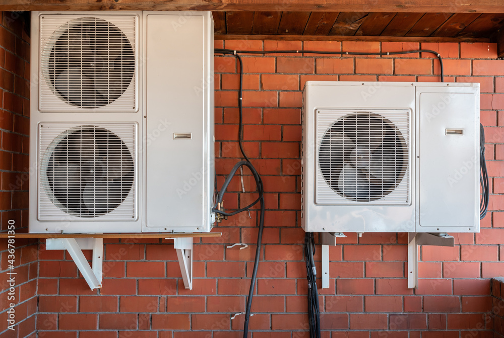 Group of air compressors outside the building wall. An air compressor