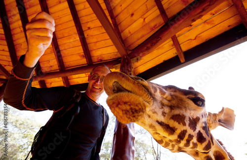 Canvas Print Tourist feeding a giraffe