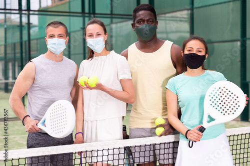 Team of men and women in protective mask after playing padel on the tennis court. High quality photo © JackF