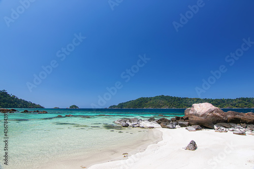 Thailand travel island "Koh Lipe" turquoise sea color white sand beach and stone coast with sunny clear blue sky background landscape