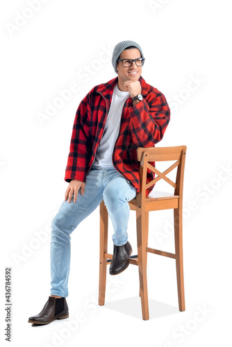 Fashionable young man sitti...
