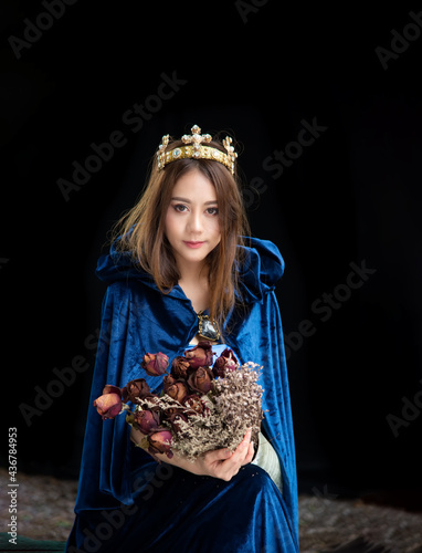 Portrait of a girl with long hair  wears a tiara with a bouquet.black background