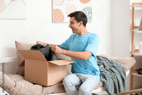 Surprised young man unpacki...