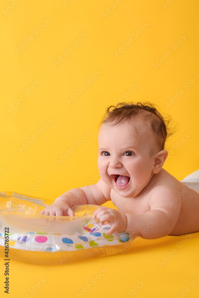 Cute baby with inflatable ring on color background