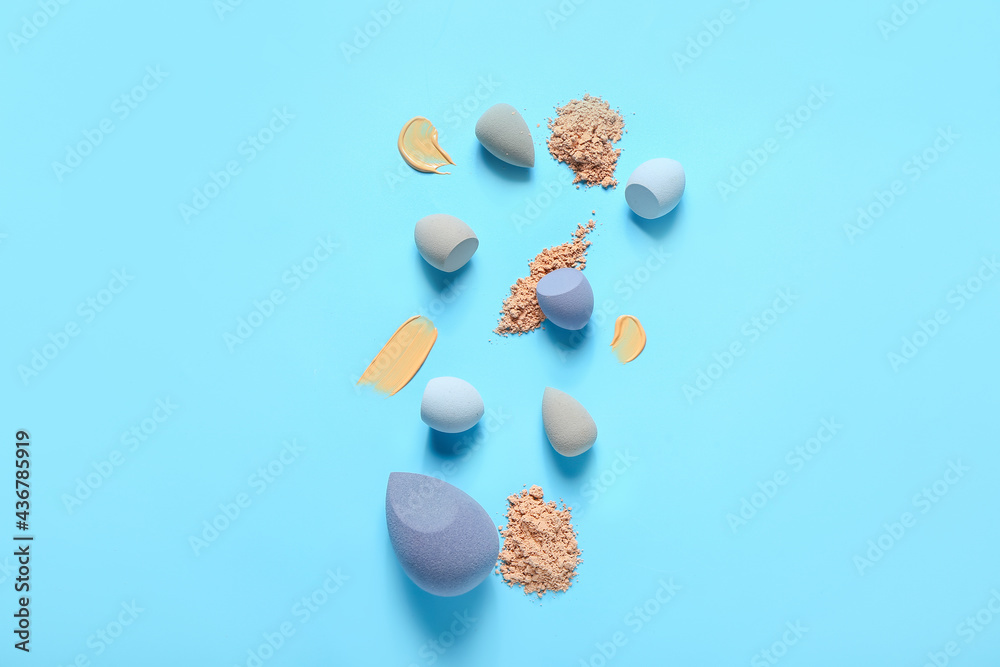Different makeup sponges, foundation and powder samples on color background Different makeup sponges, foundation and powder samples on color background