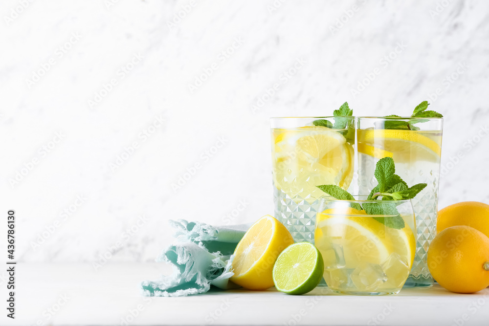 Fototapeta premium Glasses of tasty cold lemonade on light background