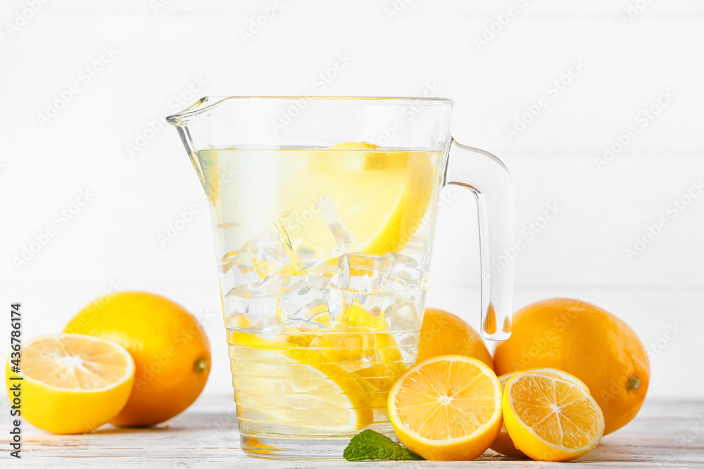 Jug of tasty cold lemonade on light background Jug of tasty cold lemonade on light background
