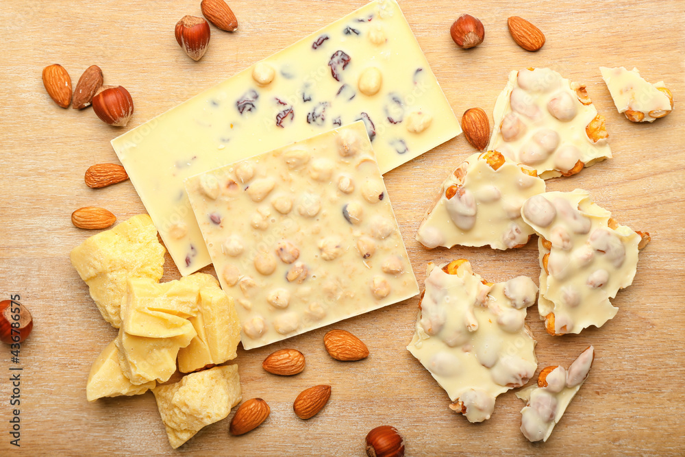 Composition with white chocolate and nuts on wooden background Composition with white chocolate and nuts on wooden background