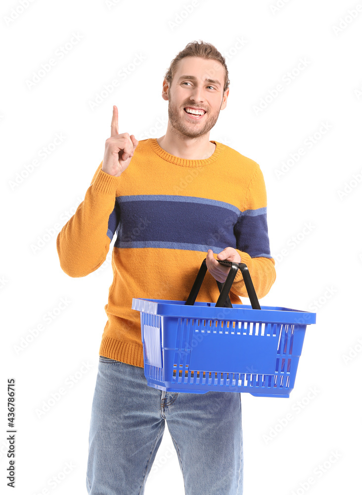 Young man with empty shopping basket and raised index finger on white background Young man with empty shopping basket and raised index finger on white background