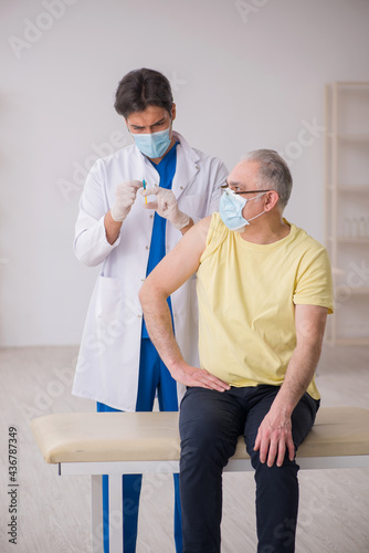 Old male patient visting young male doctor in vaccination concep