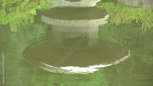 Reflection of a Japanese snow lantern (yukimi doro) in pond water. photo