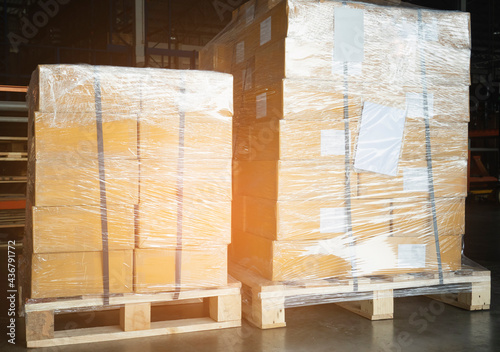 Stacked of Package Boxes Wrapped Plastic Film on Pallet at Storage Warehouse. Shipment Boxes. Cargo Export- Import.