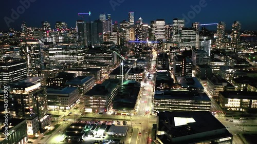 Cinematic 4K drone, after sunset, night panning clip of downtown Seattle with illuminated streets and offices looking from South Lake Union in Seattle, Washington during blue hour