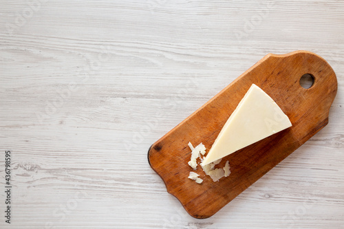Photos Pecorino Romano Cheese on a rustic wooden board on a white wooden background, top view